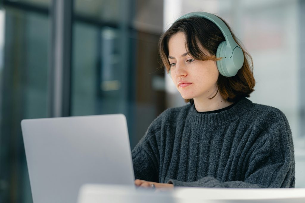 https://www.pexels.com/photo/focused-young-woman-working-on-laptop-with-headphones-29179700/