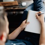 person holding orange pen