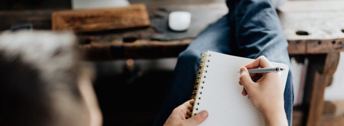 person holding orange pen